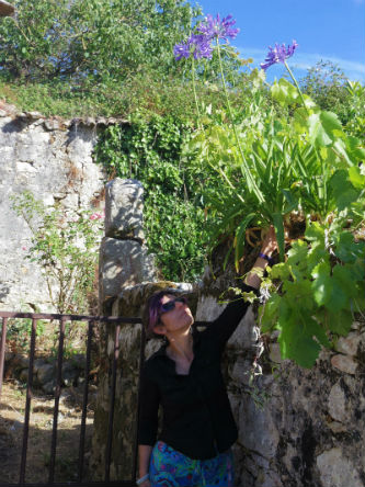 Ceci est une photo de Béatrice Pradillon-Marques tenant une agapanthe. Ceci est une photo de Béatrice Pradillon-Marques tenant une agapanthe.