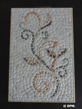 Ceci est une photo de la mosaïque de Sandrine, en galets, représentant un motif floral. Ceci est une photo de la mosaïque de Sandrine, en galets, représentant un motif floral.