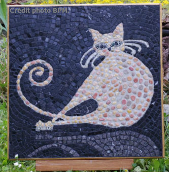 Ceci est une photo de la mosaique de Chantal, en galets et fond en marbre, représentant un chat.